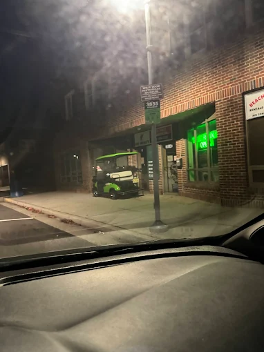 Green golf cart at night